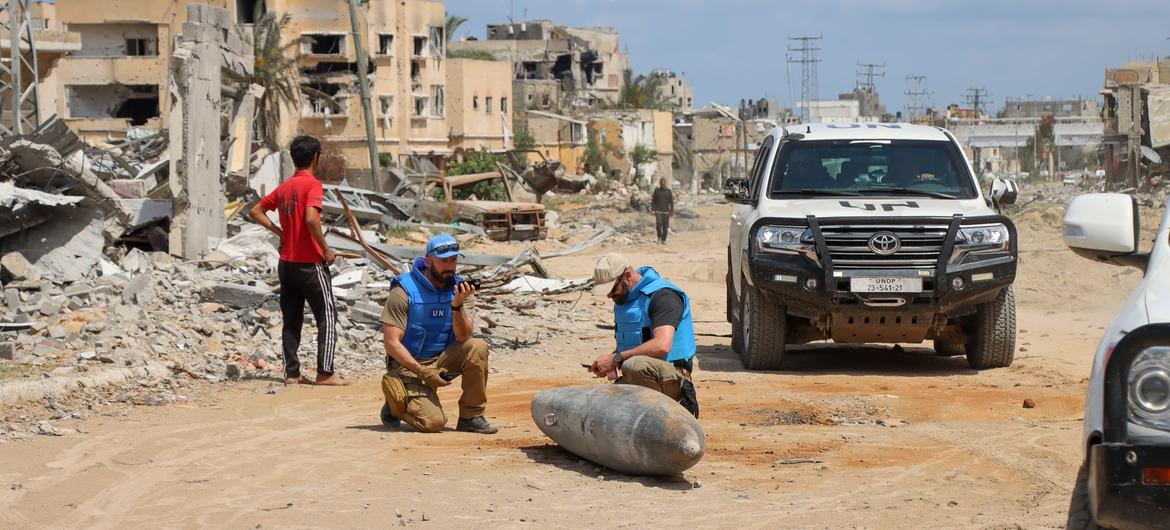 A UN team inspects an unexploded bomb lying on a main road in Khan Younis, Gaza.