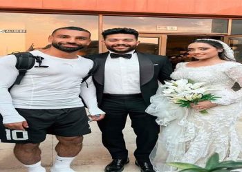صلاح يلتقط صورة تذكارية مع عرسان خلال حفل زفافهم